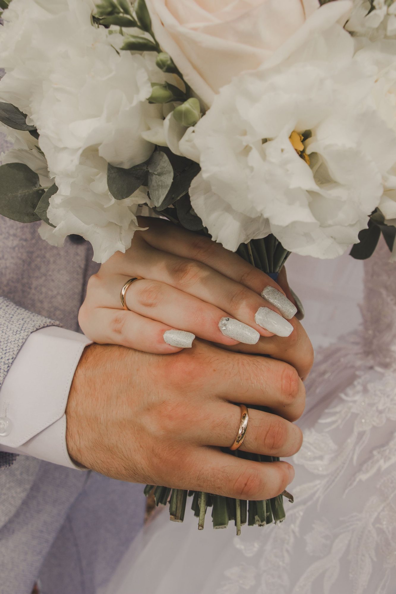 Bride and groom holding a bouquet together