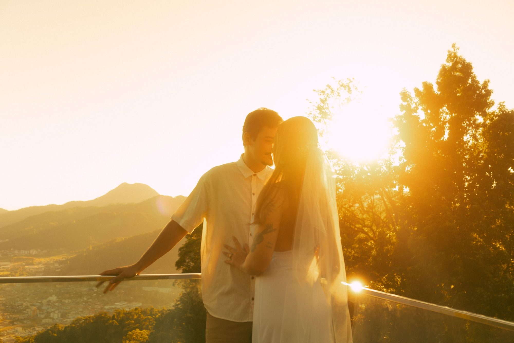 Couple embracing on a stone balcony at sunset