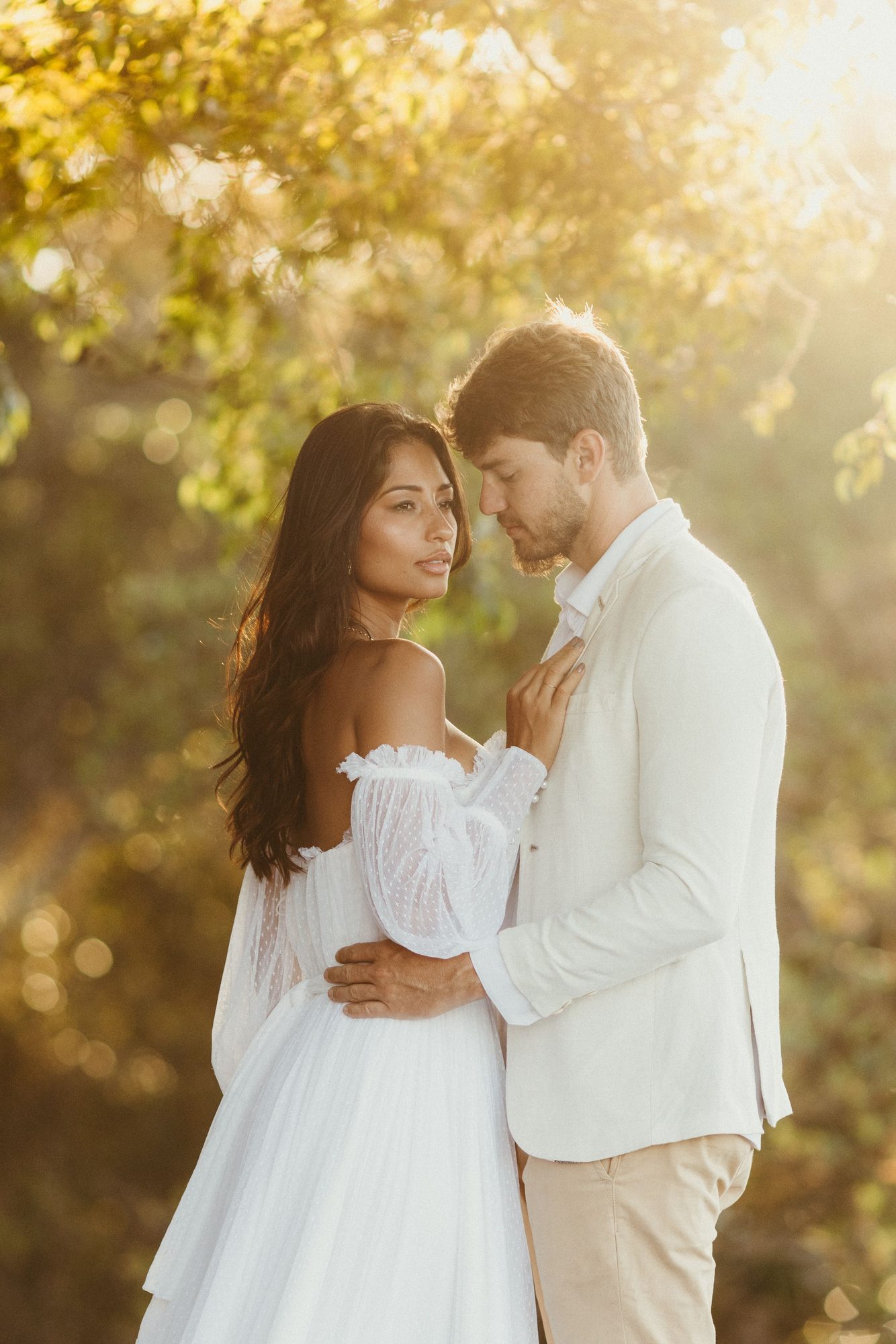 Engaged couple embracing in golden afternoon light
