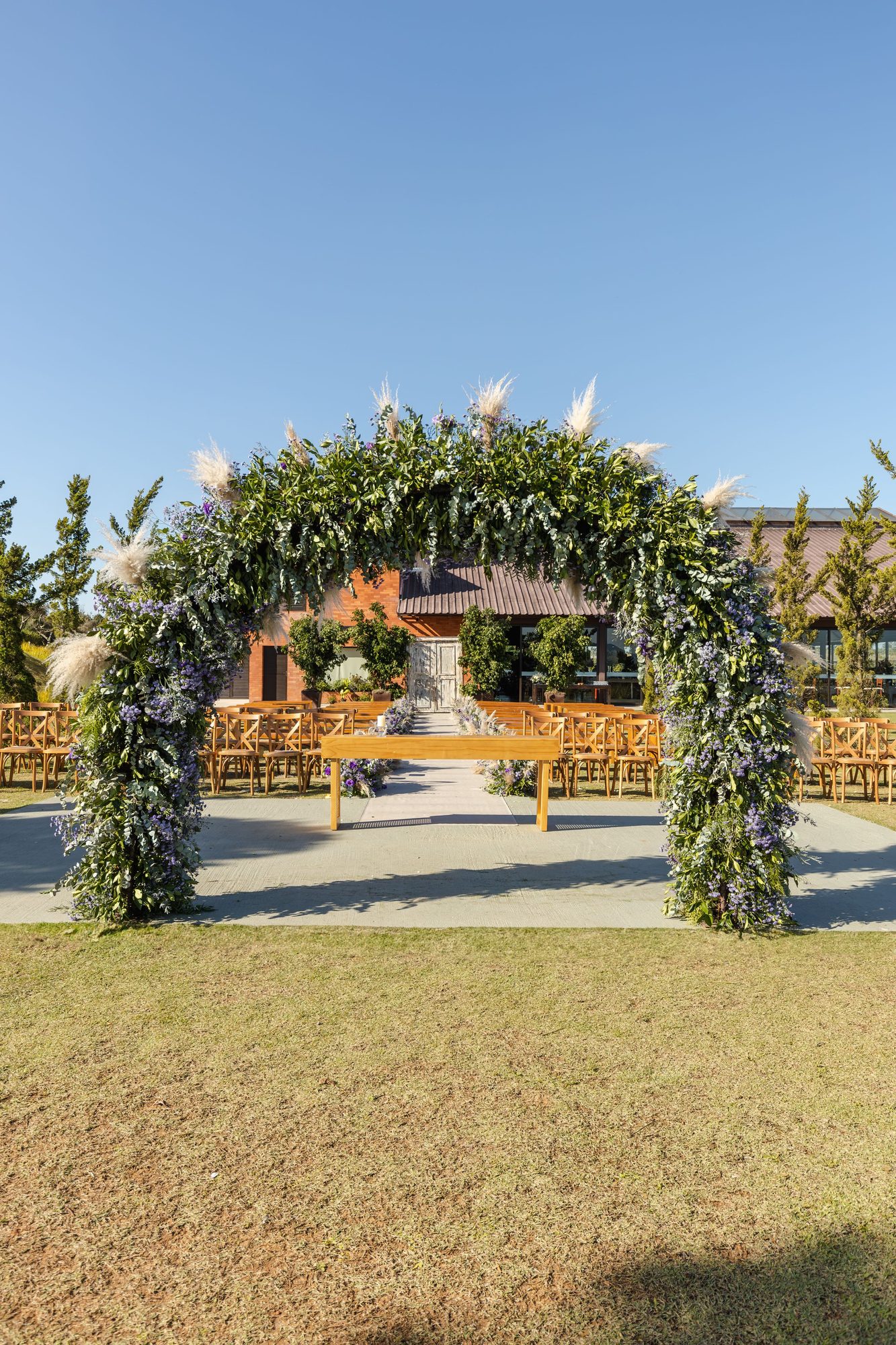 Floral arch over a garden ceremony aisle